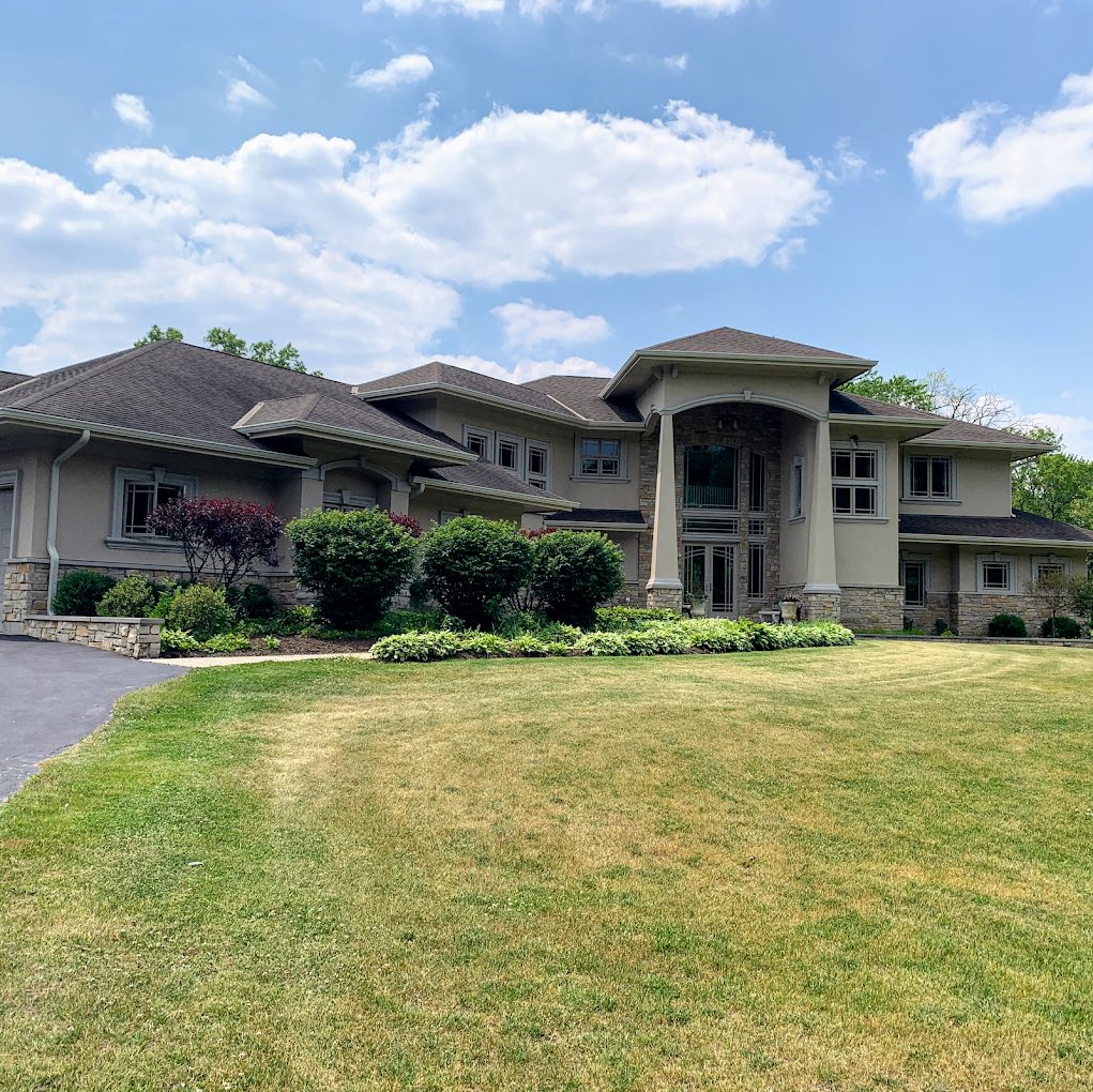 Completed seamless gutter installation on a large prairie-style home with landscaped lawn